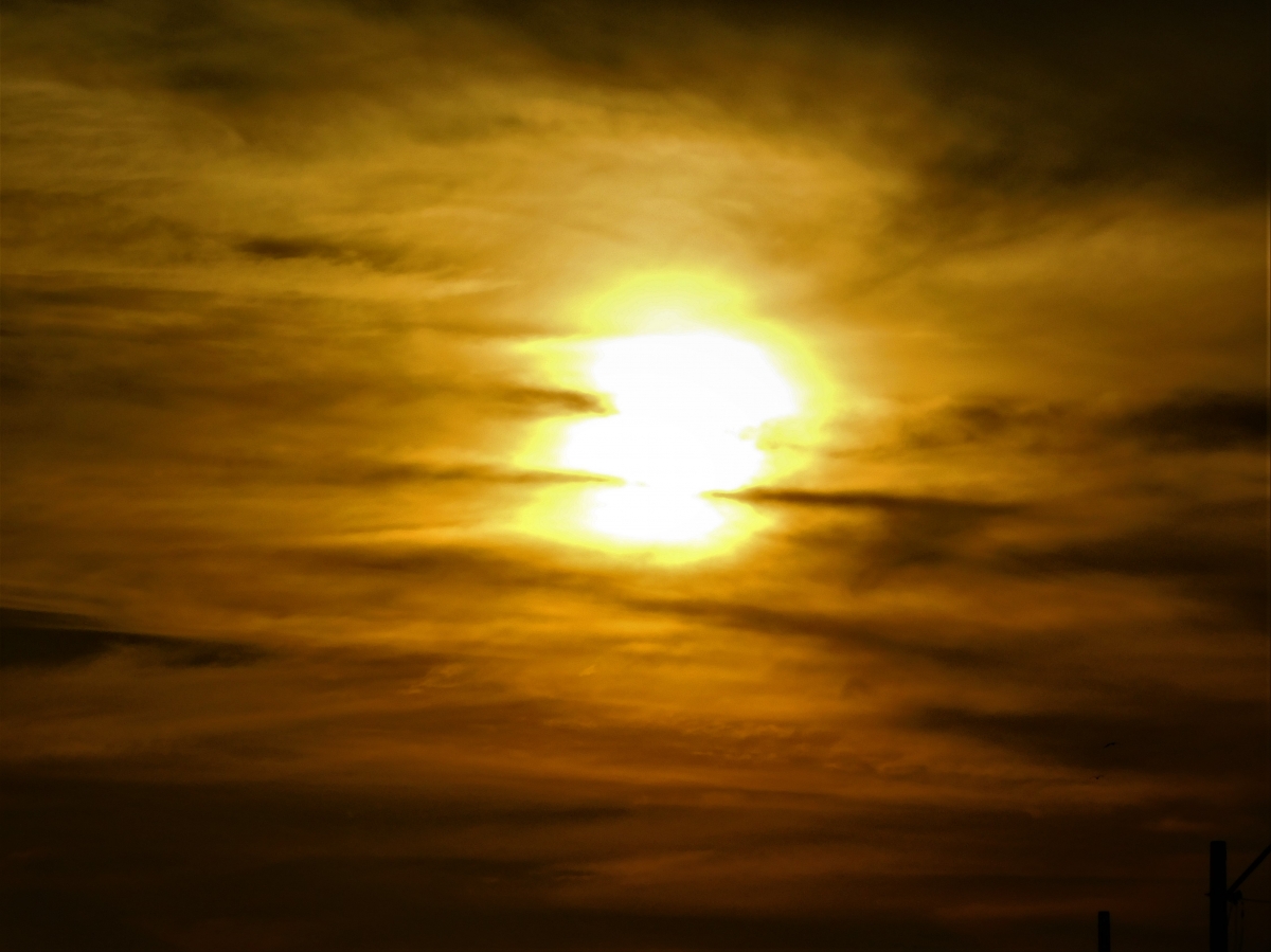 Zoom al sol rodeado de nubes