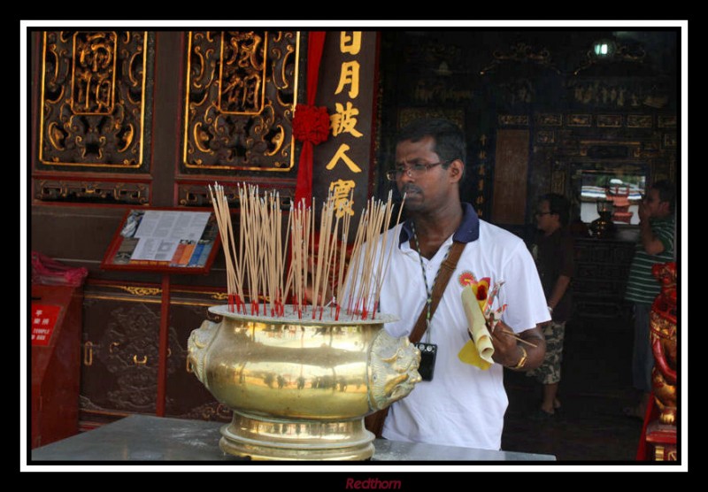 Los fieles realizan ofrendas en el templo chino