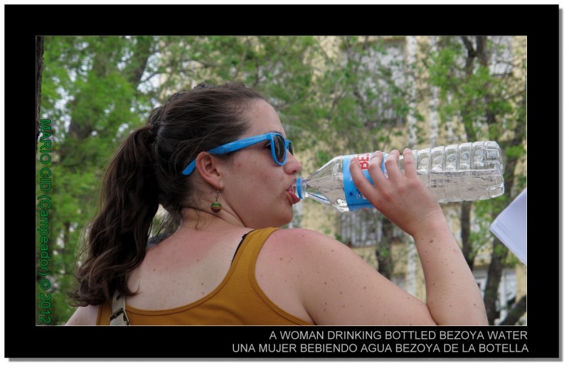 A WOMAN DRINKING BOTTLED BEZOYA WATER - UNA MUJER BEBIENDO AGUA BEZOYA DE UNA BOTELLA.  Photo by Mario Cid.