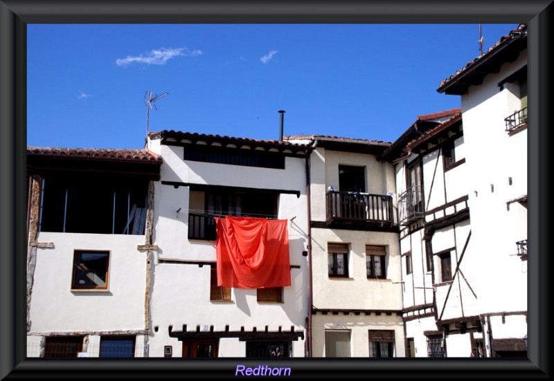 Colcha enmarcada por casas medievales con entramado de madera